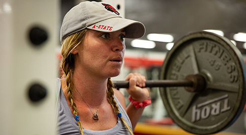 A student lifting weights on campus