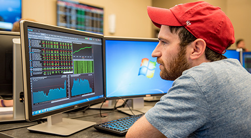 A student looking a stock market trends on a computer