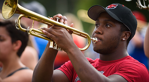 A marching band student playing the trumpet