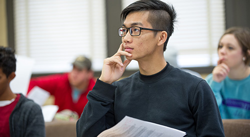 A student intently listening to the classroom instructor